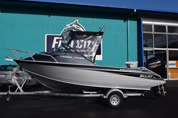 Grey and black boat with black mercury motor and soft top canopy in front of fish city