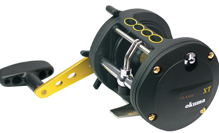 Black reel with gold screws, and a black and gold handle. There is branding printed on the side of the reel body